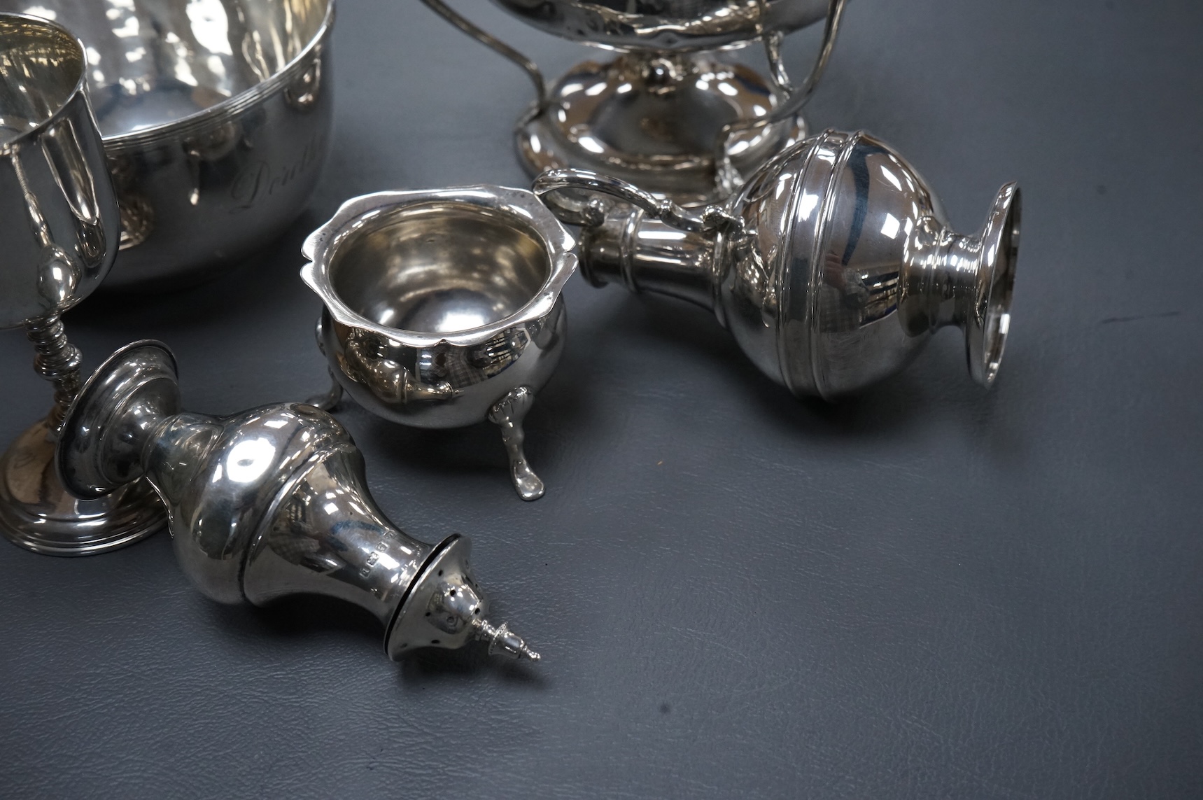A collection of small silver including an Edwardian Art Nouveau tri-handled pedestal bowl, Birmingham, 1909, height 90mm, a sugar bowl, three cigarette cases, goblet, communion jug, five condiments, three napkin rings, e